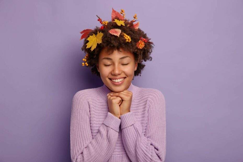 Femme métisse cheveux secs remplis de feuilles d'automne