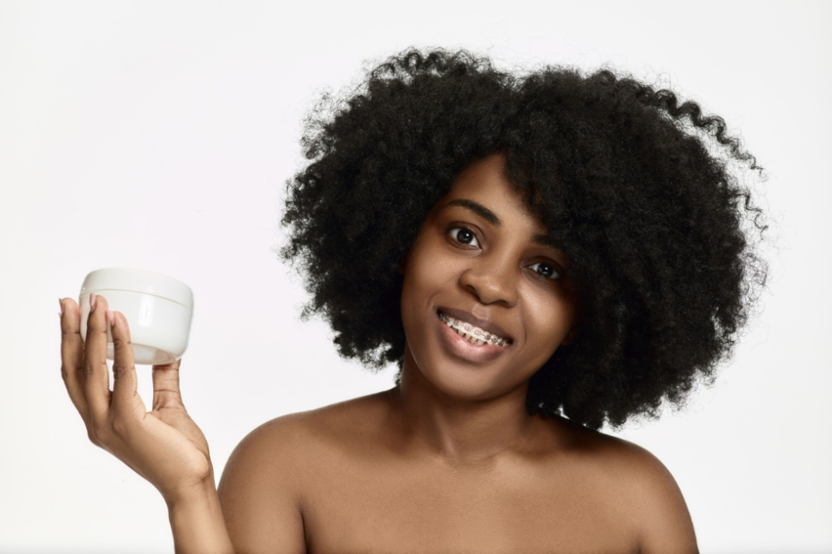 Femme noire brandissant une crème hydratante