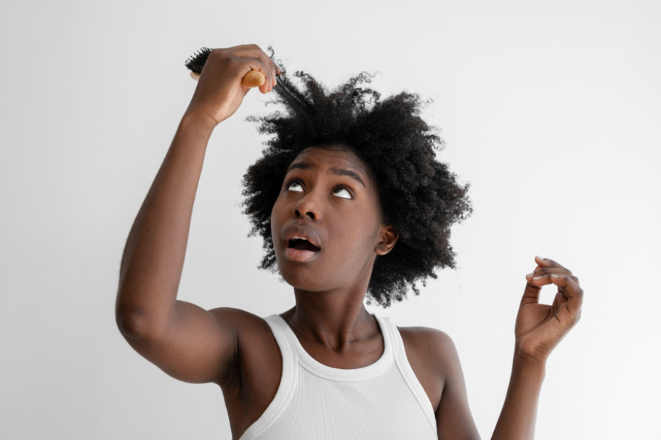 Femme noire constatant les effets de soins contenant du sulfate sur ses cheveux