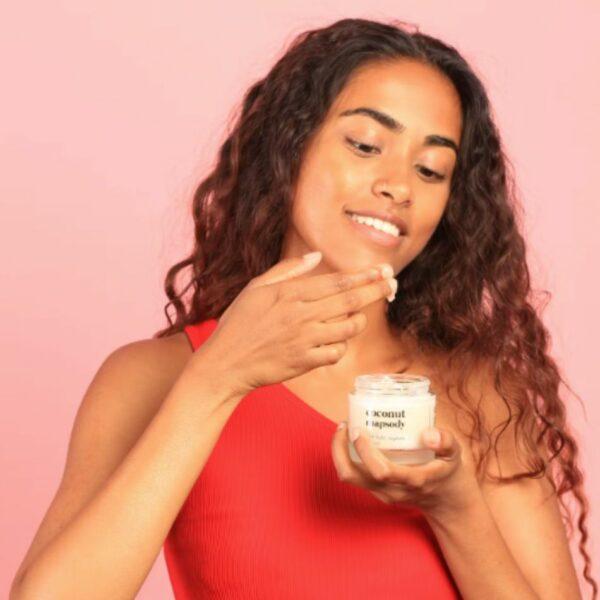Huile de coco MIRA - femme métisse tenant une noisette d'huile de coco sur les doigts